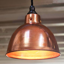 Small polished copper pendant light switched on