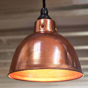 Small polished copper pendant light switched on