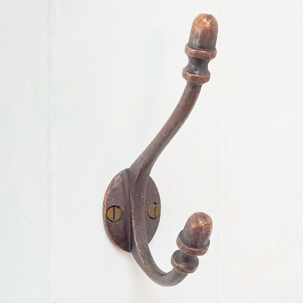 Antique copper acorn wall hook against white painted panelling
