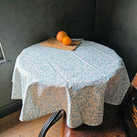 Circular Aqua coral wipe clean tablecloth on a round table.