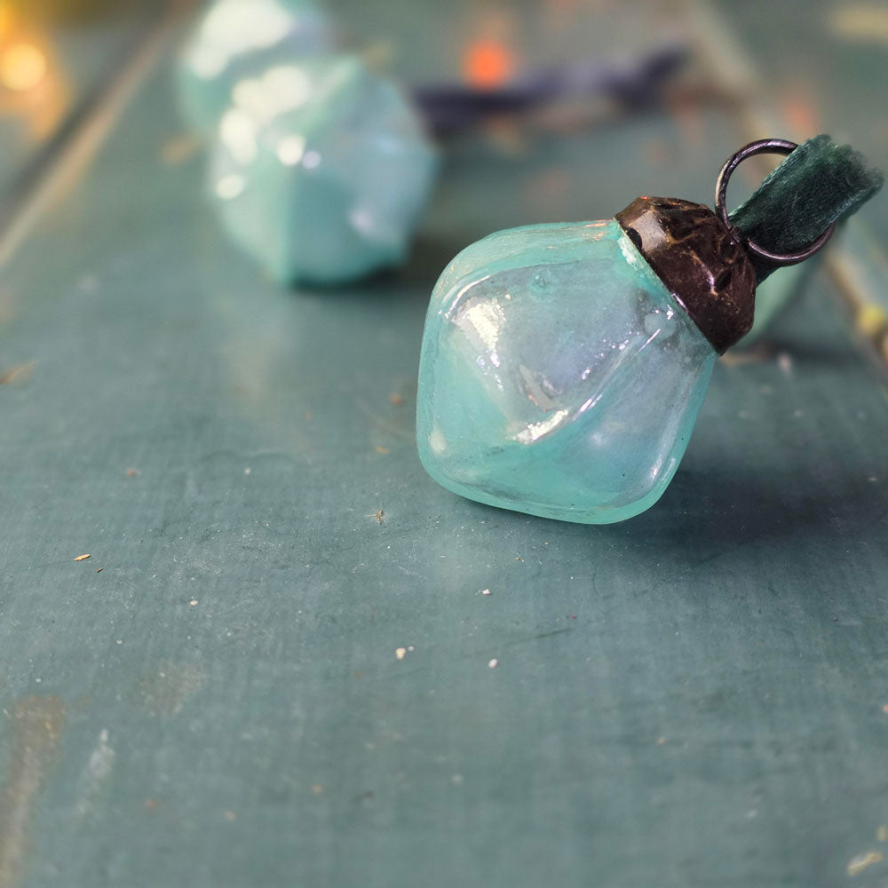 Aqua Glass Christmas decorations on a table surface.
