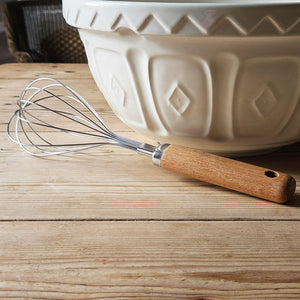 Beech wood handled balloon whisk on a kitchen table