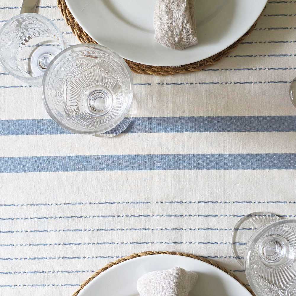 Table setting with striped table runner, glasses, and plates.
