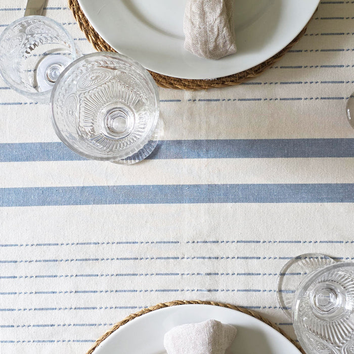 Table setting with striped table runner, glasses, and plates.