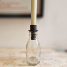 Antique brown bottle candle holder in small glass bottle.