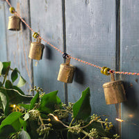 Decorative string with brass bells against a wooden background