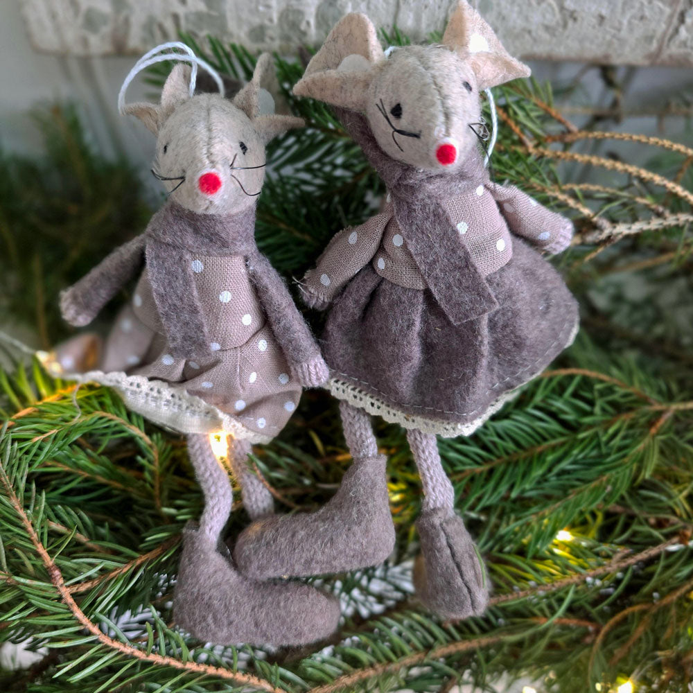 Pair of brown felt mice Christmas decorations seated upon Spruce Christmas foliage.