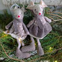 Pair of brown felt mice Christmas decorations seated upon Spruce Christmas foliage.