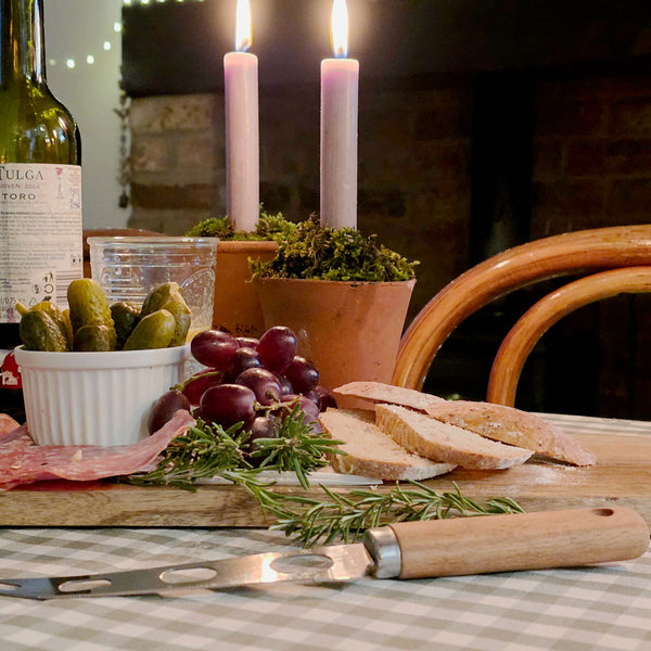 Antipasti on a long wooden charcuterie board at Christmas.
