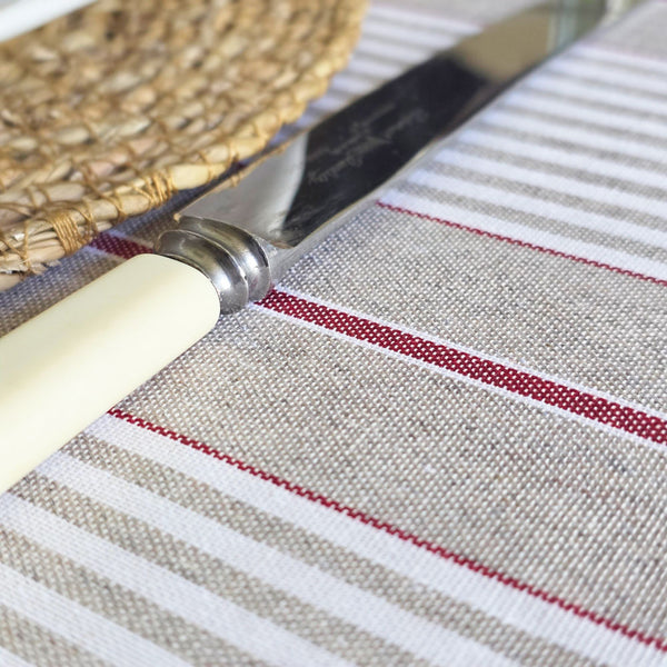 Close up of wipe clean red striped tablecloth placemat and dinner knife.