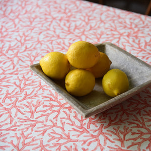 Coral print oilcloth under a bowl of lemons