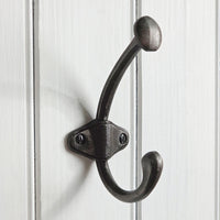 Black double hook on a white wooden background