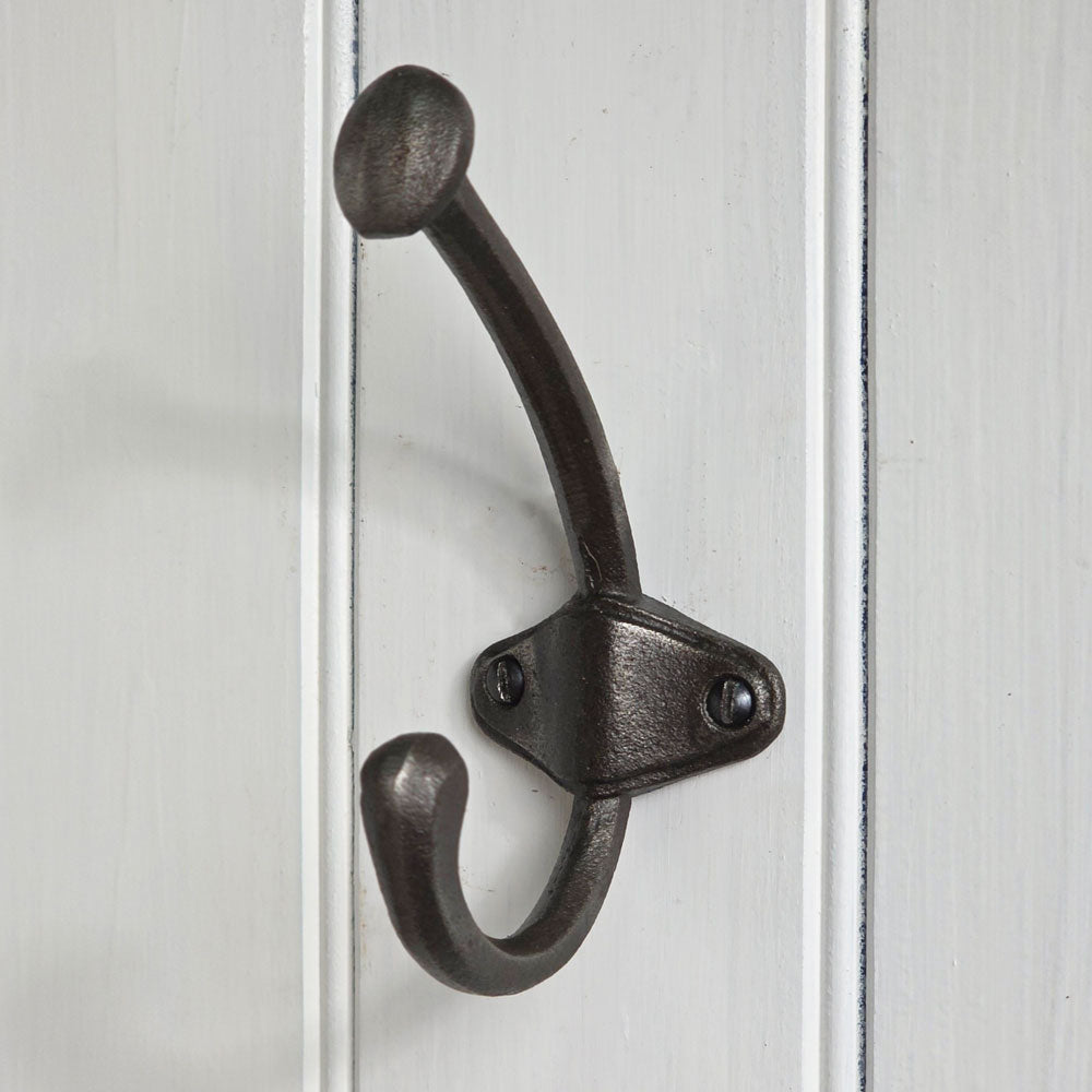 Black metal double hook on a white wooden panel
