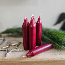 Danish red short dinner candles next to Christmas decorations