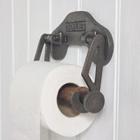 Metal toilet paper holder with 'TOILET' label on a white background