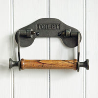 Metal and wood toilet paper holder on a white wooden background