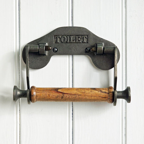 Metal and wood toilet paper holder on a white wooden background