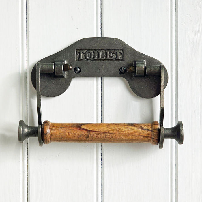 Metal and wood toilet paper holder on a white wooden background