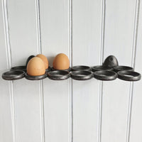 Egg holder with three eggs on a white wooden background