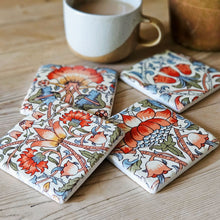 Set of four  floral design drinks coaters on a kitchen table.