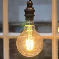 Vintage-style light bulb with a warm glow against a blurred background