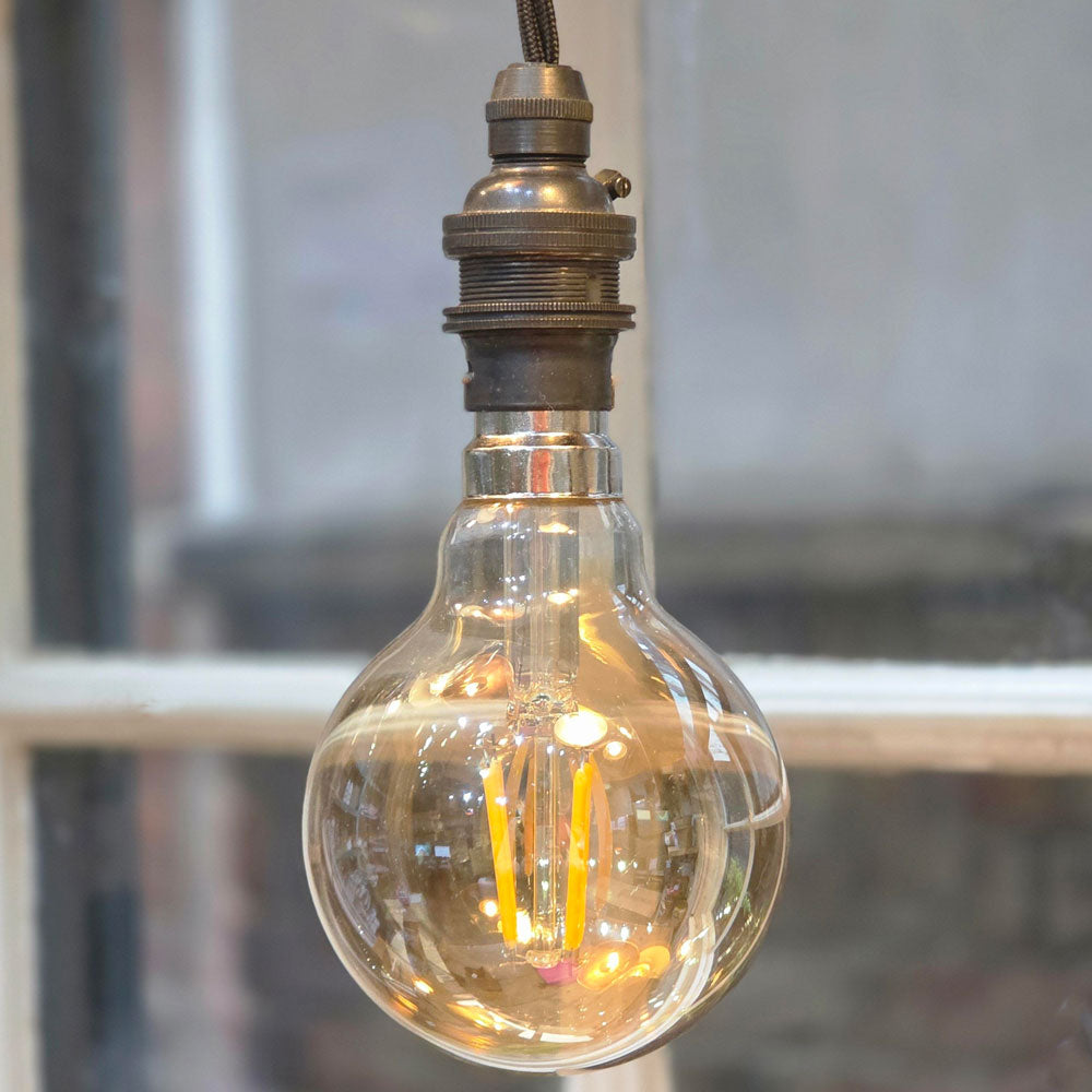Vintage-style light bulb hanging against a blurred background