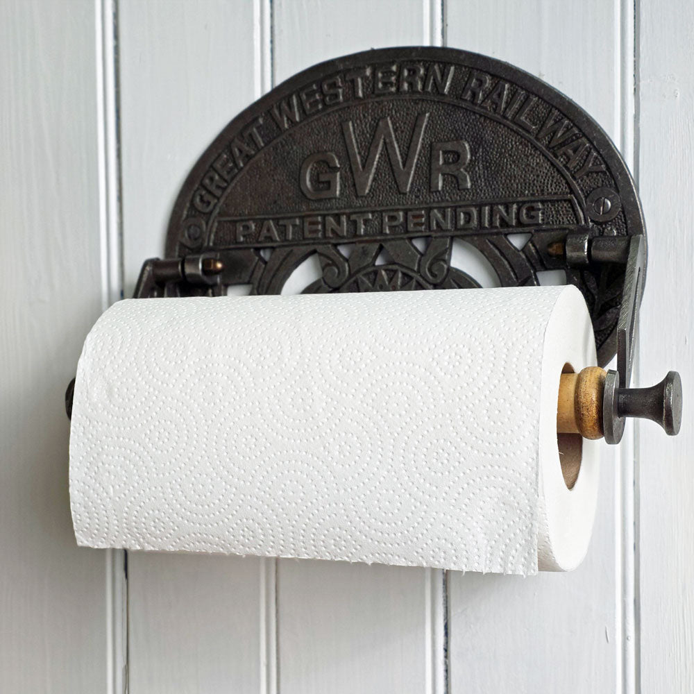 Vintage-style paper towel holder with 'GWR' branding on a white wall.