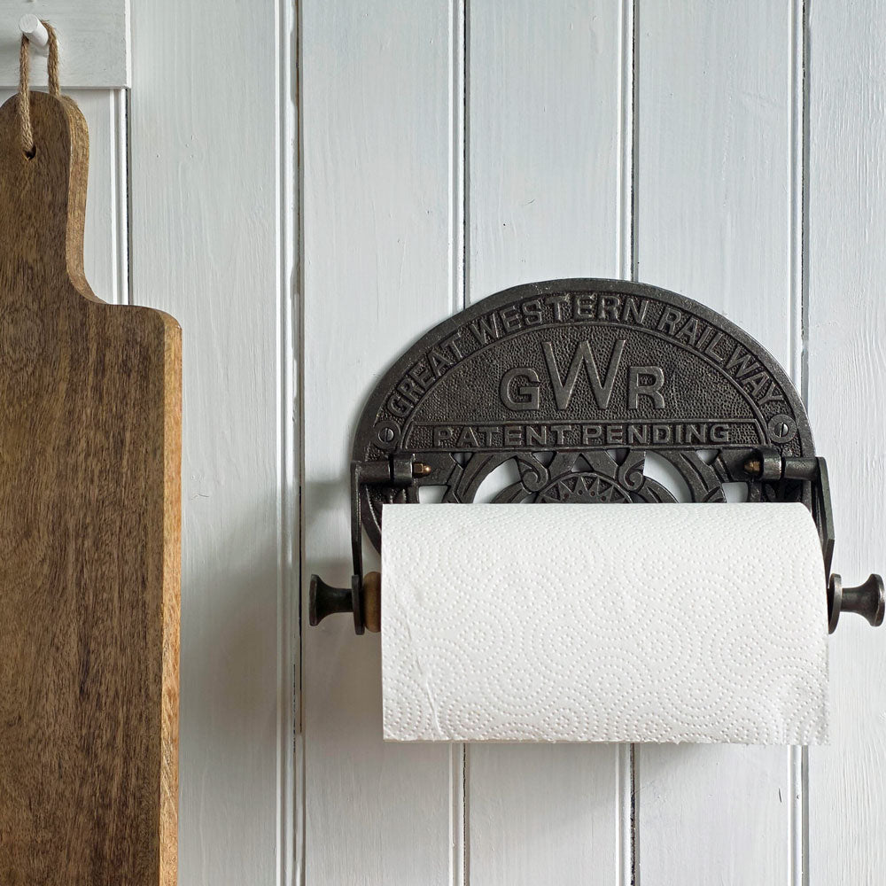 Wall-mounted paper towel holder with 'GWR' branding on a white paneled wall.
