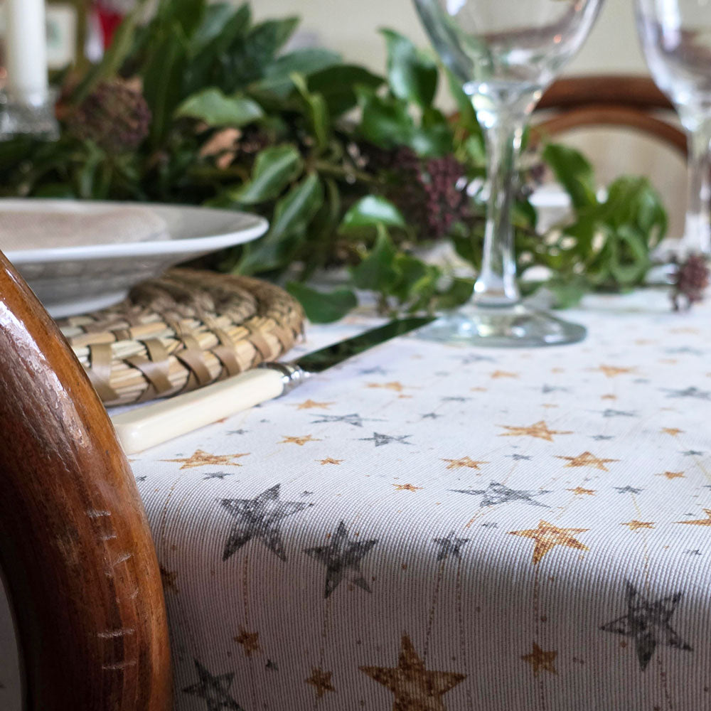 Gold and silver stars wipe clean tablecloth on a Christmas table.
