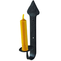 A black metal wall-mounted candle holder with a pointed top and curved hook base, shown holding a single yellow taper candle against a plain white background.
