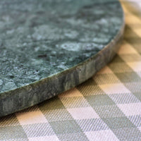 Green marble cutting board on a checkered tablecloth