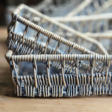 Grey Scandinavian style flat wicker storage baskets on a pine table