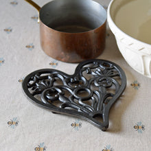 Heart shaped cast iron pan trivet placed on table