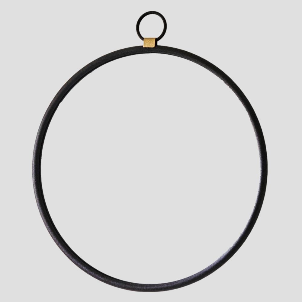 Black circular metal ring with a gold accent on a light gray background