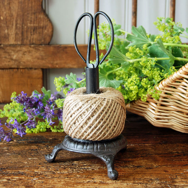 Cast iron garden twine holder on a bench.