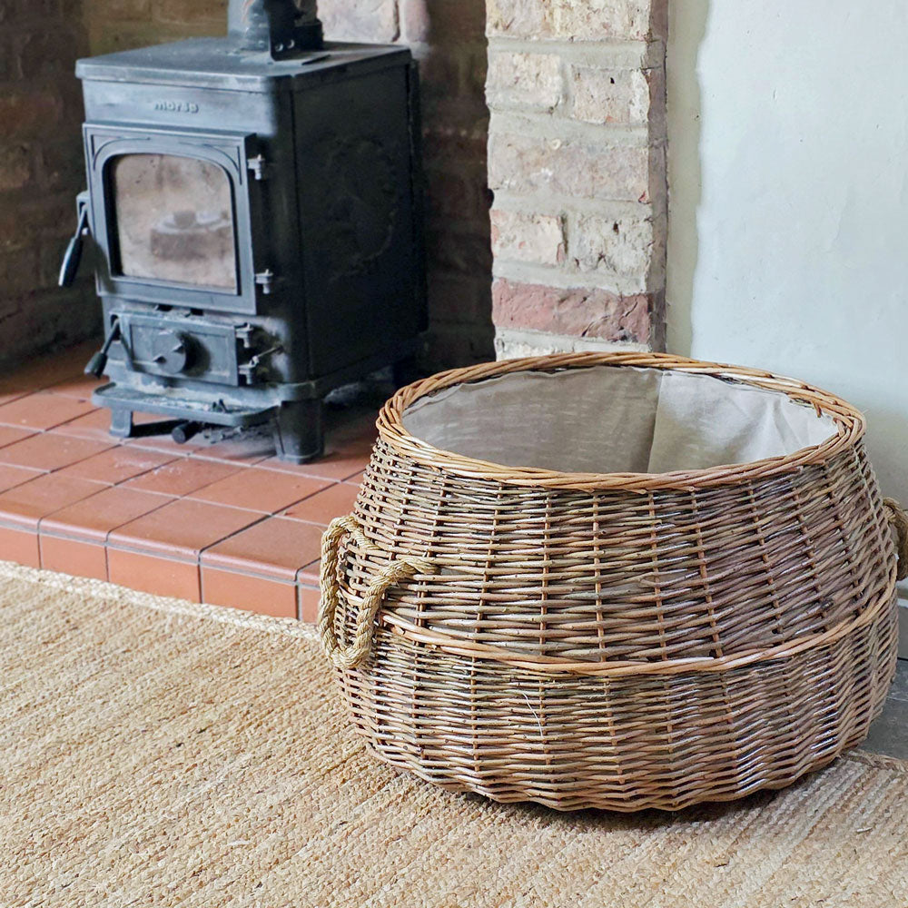 Wicker basket in front of a wood stove in a cozy room.