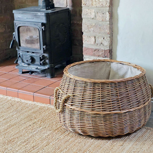 Wicker basket in front of a wood stove in a cozy room.