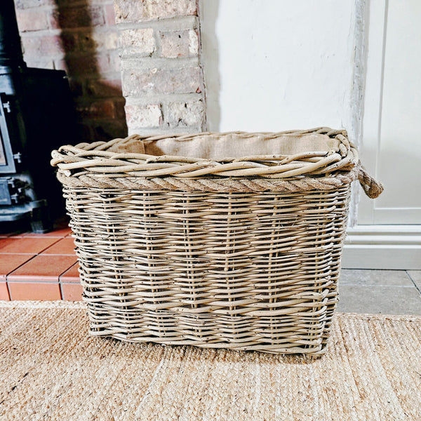 Large wicker mill style log basket on a fireside.