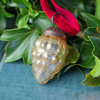 Small glass vintage style Christmas decoration with greenery.
