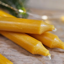 Mustard dinner candles next to Christmas lights