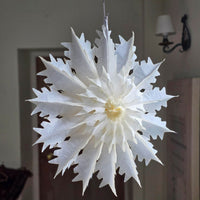 White paper snowflake decoration hanging indoors.