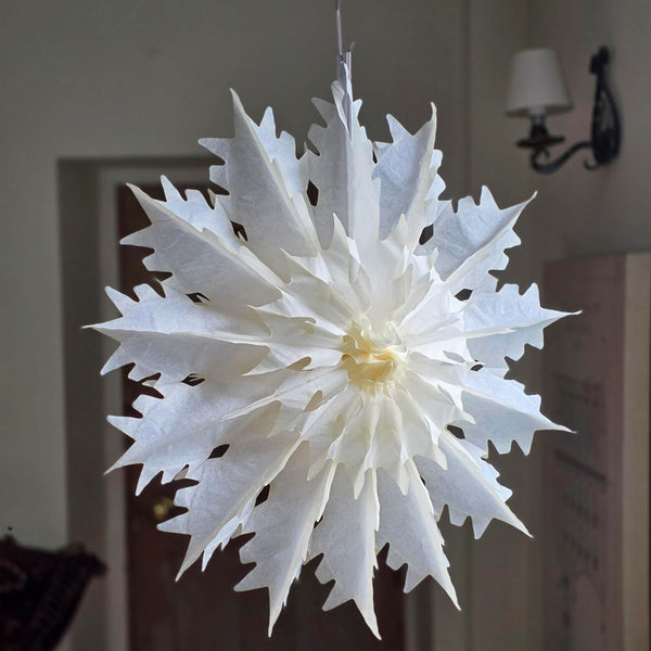 White paper snowflake decoration hanging indoors.