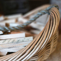 Close-up of a wicker basket with kindling inside, blurred background.