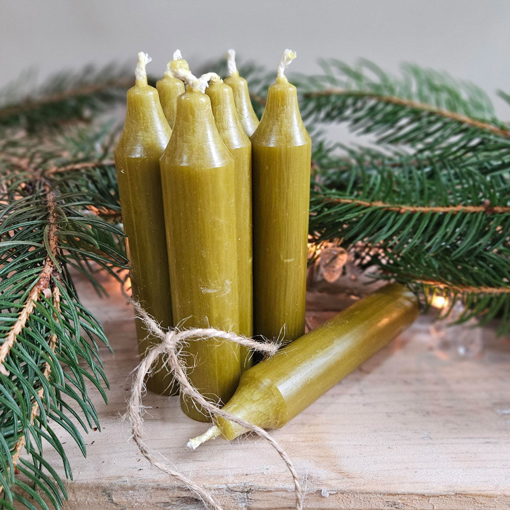 Hand tied bundle seven Danish dinner candles  with Christmas foliage.