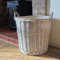 Small Provence washed willow log basket next to a log burner.