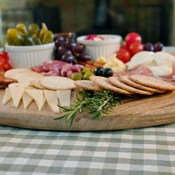 Close up of round charcuterie board laden with antipasti.