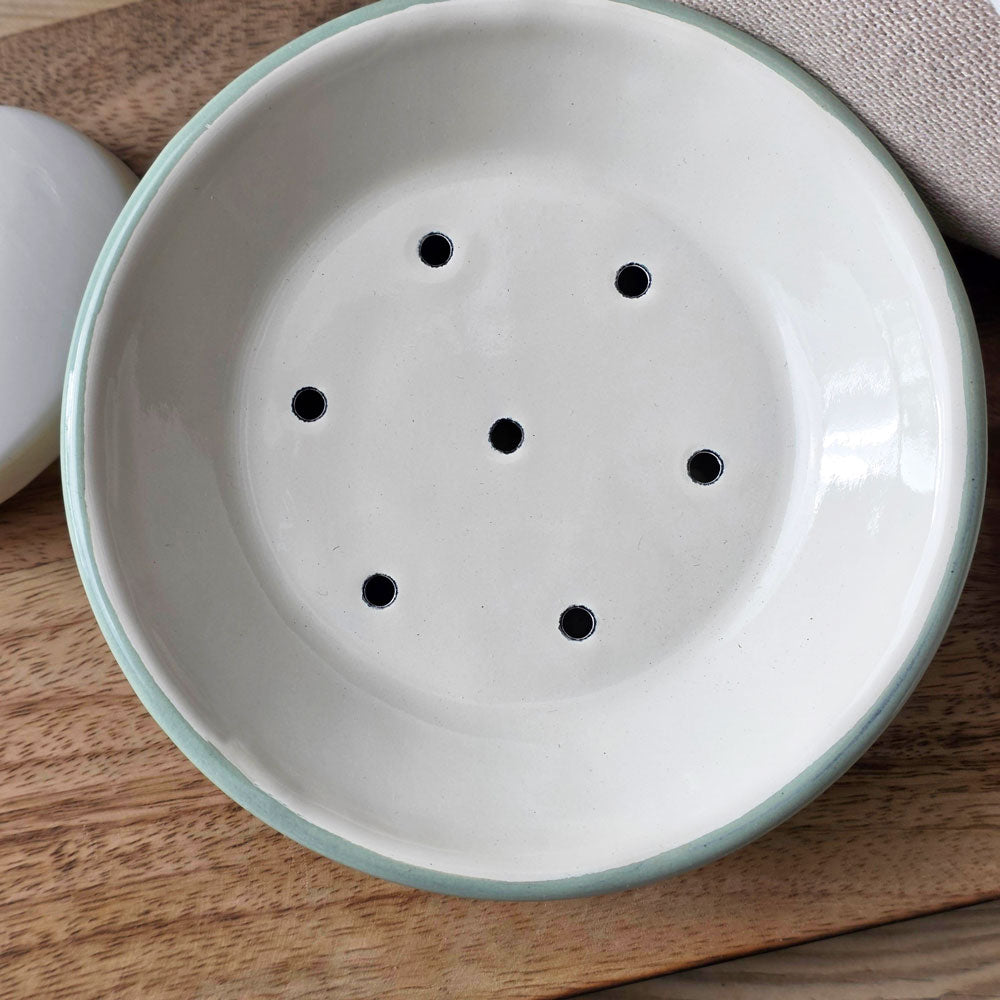 Aerial view of a round green and white enamel soap dish
