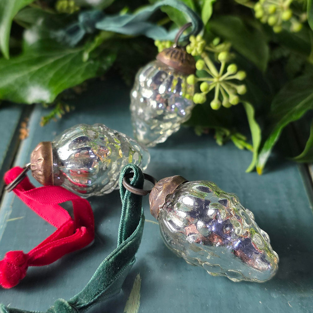 Various antique glass tree baubles on a blue surface.