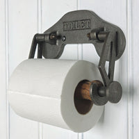 Vintage-style metal toilet paper holder with a roll of toilet paper on a white wooden background