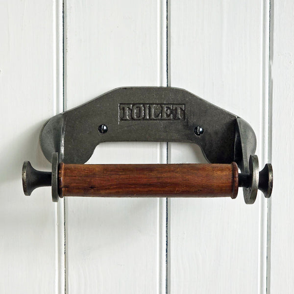 Vintage-style metal and wooden toilet paper holder on a white wooden panel background